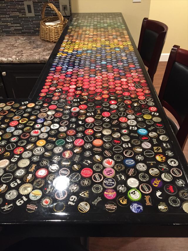 バーカウンターに並べられたビール瓶のキャップ